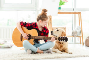 Girl playing guitar with lovely dog